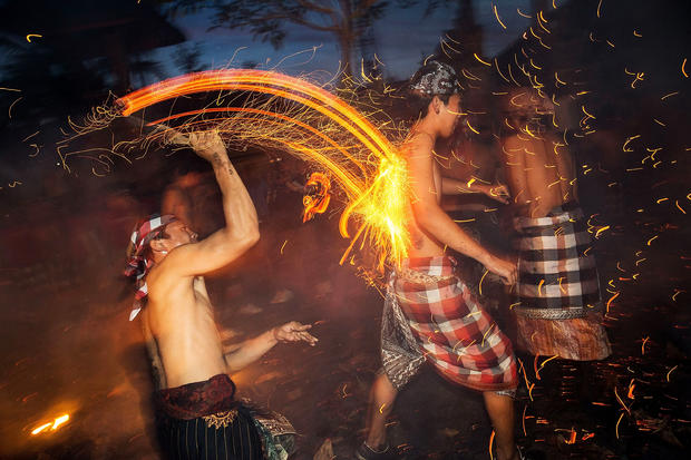 Balinese men play with burning coconut husks to celebrate Nyepi Day 