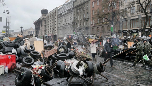People pass by barricades near the Dnipro Hotel in center Kiev, Ukraine 