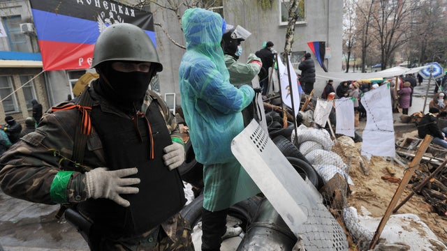 Pro-Russia activists guard a barricade outside a regional police building seized by armed separatists in Slovyansk 