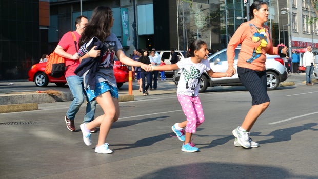 People evacuate buildings after a strong earthquake rattled Mexico City April 18, 2014. 