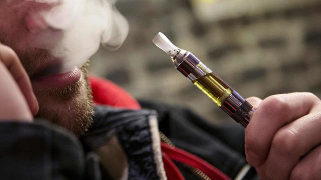 Man puffs on e-cigarette in December 2013 file photo 