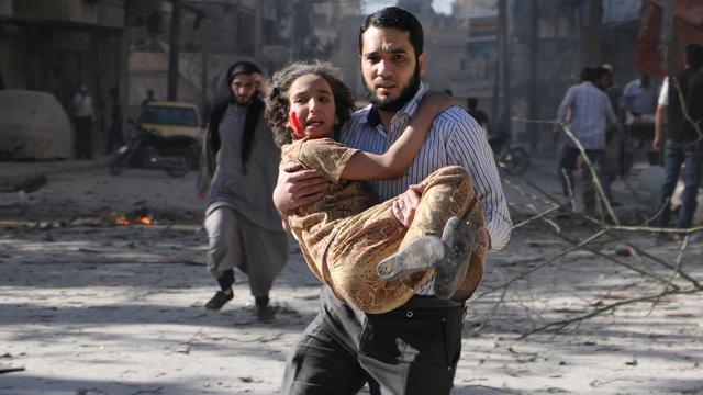 A man carries a wounded girl following a reported bombardment with explosive-packed "barrel bombs" by Syrian government forces in the Al-Mowasalat neighborhood in the northern Syrian city of Aleppo 