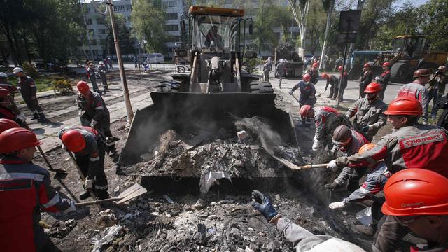 Workers of Metinvest, majority-owned by Rinat Akhmetov's System Capital Management, remove barricades and debris in front of the City Hall in Mariupol 