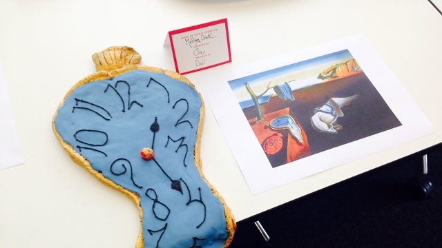 A cake inspired by ​Salvador Dali's "The Persistence of Memory" is seen next to a picture of the painting. 
