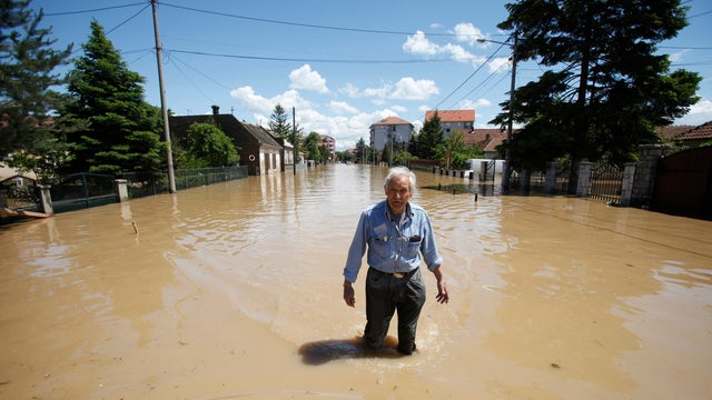 A man walks through flood water in the town of Obrenovac 