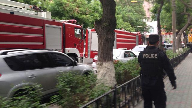 Policeman and firetrucks are seen near site of explosions in street market in Xinjiang region of China on May 22, 2014 