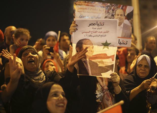 Supporters of Abdel-Fattah el-Sissi hold poster of him as they celebrate at Tahrir Square in Cairo on May 28, 2014 