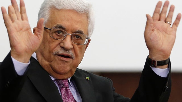 Palestinian President Mahmoud Abbas waves during a swearing-in ceremony of the unity government in the West Bank city of Ramallah 