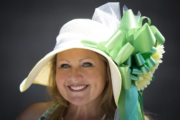 Brooke Maiello poses for a portrait with her colorful hat before the 146th running of the 2014 Belmont Stakes in Elmont, New York, June 7, 2014. 