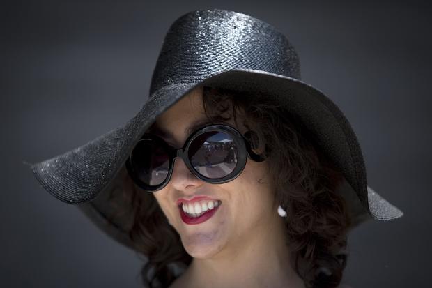 Leah Heather poses for a portrait with her hat before the 146th running of the 2014 Belmont Stakes in Elmont, New York, June 7, 2014. 