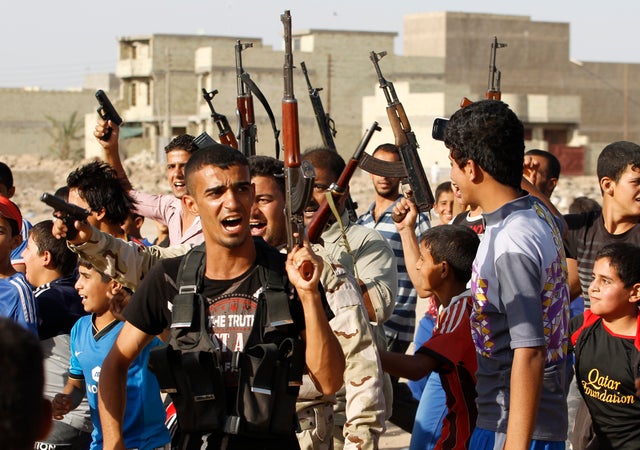 Volunteers who have joined the Iraqi army to fight against predominantly Sunni militants from the radical Islamic State of Iraq and Syria (ISIS), carry weapons during a parade in the streets in Al-Fdhiliya district in eastern Baghdad June 15, 2014. 