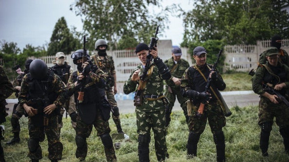 Pro-Russian gunmen stand at a checkpoint outside of the eastern Ukrainian city of Donetsk  