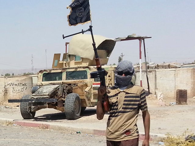 A fighter of the Islamic State of Iraq and Syria (ISIS) stands guard at checkpoint near the city of Baiji 