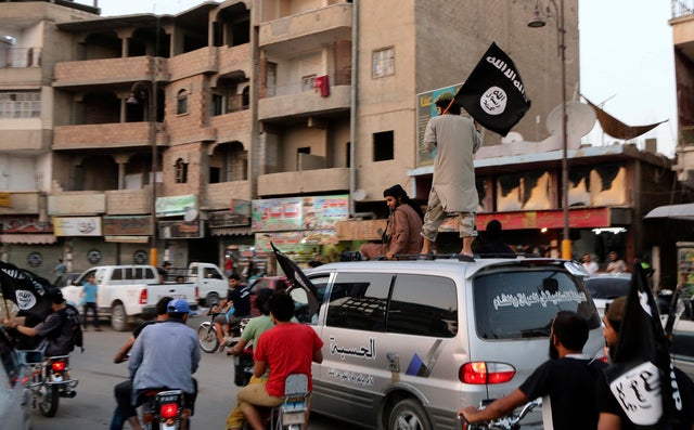 ISIS loyalists wave ISIS flags as they drive around Syrian city of Raqqa on June 29, 2014 