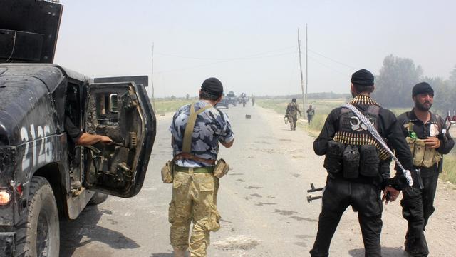 Iraqi security forces and armed volunteers move with military vehicles during clashes with militants of the Islamic State of Iraq and Syria (ISIS), in the town of Dalli Abbas in Diyala province 