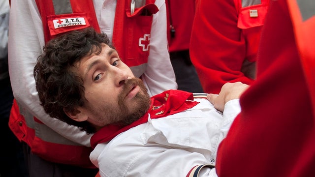 U.S. runner Bill Hillmann, 35, from Chicago, is carried on a stretcher after being gored on his right leg by a Victoriano del Rio ranch fighting bull during the running of the bulls at the San Fermin festival in Pamplona, Spain, July 9, 2014. 