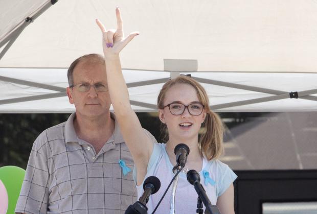 Cassidy Stay stands with her grandfather, Roger Lyon, as she addresses the crowd during a memorial service for members of the Stay family who were murdered in their home in Spring, Texas, July 12, 2014. 