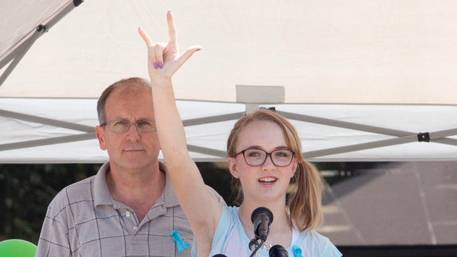 Cassidy Stay stands with her grandfather, Roger Lyon, as she addresses the crowd during a memorial service for members of the Stay family who were murdered in their home in Spring, Texas, July 12, 2014. 