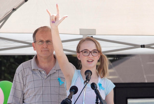 Cassidy Stay stands with her grandfather, Roger Lyon, as she addresses the crowd during a memorial service for members of the Stay family who were murdered in their home in Spring, Texas, July 12, 2014.