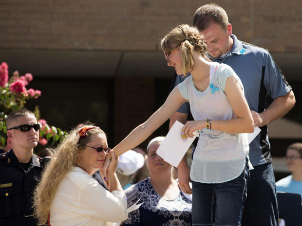 A supporter greets Cassidy Stay, far right, lone survivor of the mass shooting of her parents and siblings, during a community memorial celebrating the lives of the Stay family at Lemm Elementary School July 12, 2014, in Spring, Texas. 