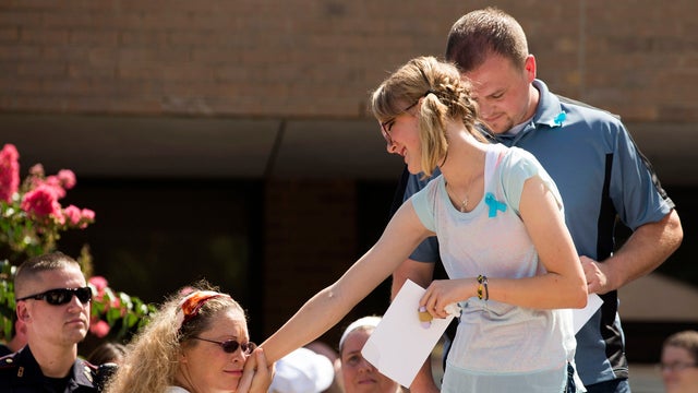 A supporter greets Cassidy Stay, far right, lone survivor of the mass shooting of her parents and siblings, during a community memorial celebrating the lives of the Stay family at Lemm Elementary School July 12, 2014, in Spring, Texas. 