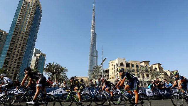 Cyclists ride their bikes past Burj Khalifa, the world's tallest tower, during the fourth and last stage of the Dubai Cycling Tour 2014 Feb. 8, 2014, in Dubai, United Arab Emirates. 