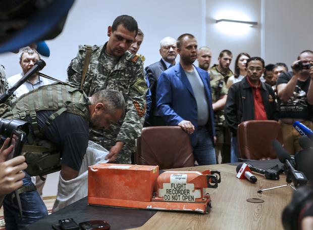 A pro-Russia separatist shows members of the media a "black box" from Malaysia Airlines flight 17, before handing it over to Malaysian representatives during a press conference in Donetsk 