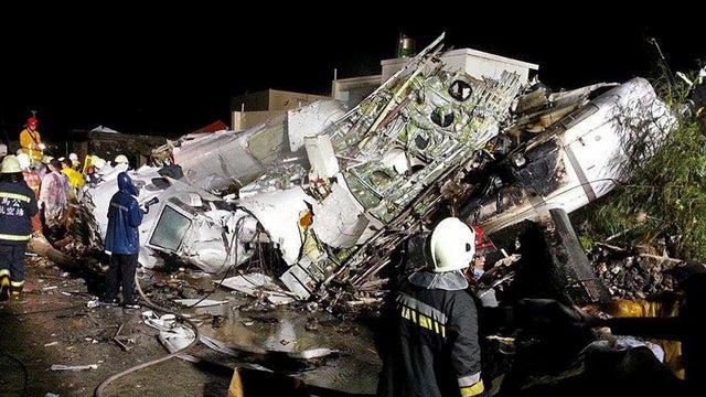 Rescue workers survey the wreckage of TransAsia Airways Flight GE222, which crashed while attempting to land in stormy weather on the Taiwanese island of Penghu July 23, 2014. 