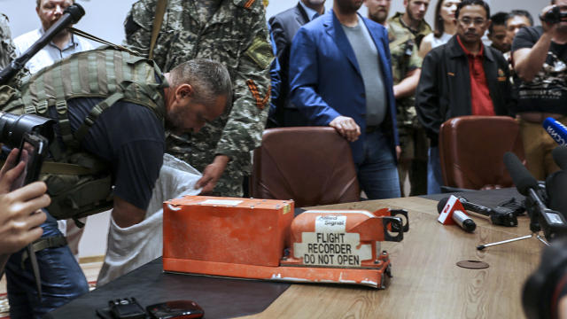A pro-Russia separatist shows members of the media a black box belonging to Malaysia Airlines Flight 17 before handing it over to Malaysian representatives during a press conference in Donetsk, Ukraine, July 22, 2014. 