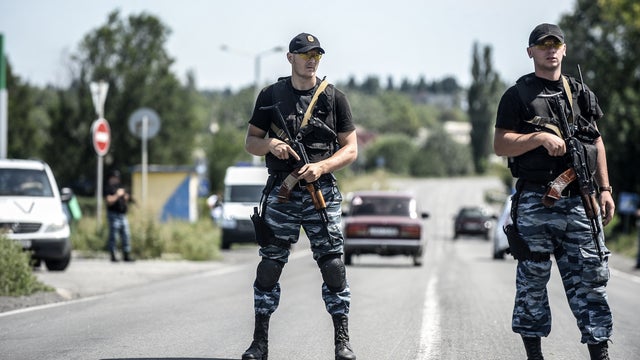 Pro-Russian militants block the road behind Dutch and Australian forensic teams on their way to the crash site of Malaysia Airlines Flight 17 