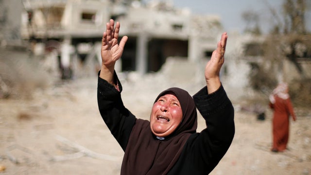 A Palestinian woman reacts upon seeing her destroyed house in Beit Hanoun, northern Gaza, which witnesses said was heavily hit by Israeli shelling and airstrikes 
