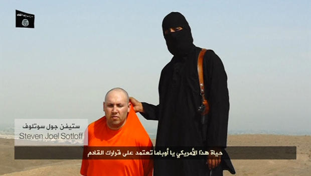 A masked Islamic State of Iraq and Syria militant speaks next to a man purported to be U.S. journalist Steven Sotloff at an unknown location in this still image from an undated video posted on a social media website. 