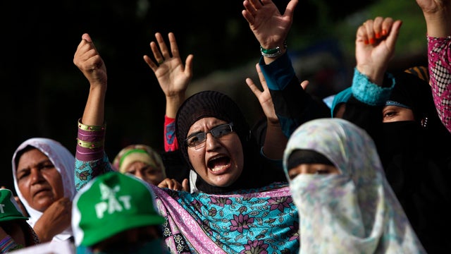 ​Supporters of Tahirul Qadri, Sufi cleric and leader of political party Pakistan Awami Tehreek (PAT), gesture as they chant slogans during the Revolution March in Islamabad Aug. 18, 2014. 