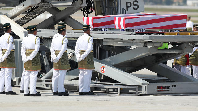 A plane carrying the bodies of 20 Malaysians killed in the downing of Malaysia Airlines Flight MH17 over Ukraine arrives and the coffins are prepared to be carried by Army soldiers at Kuala Lumpur International Airport 