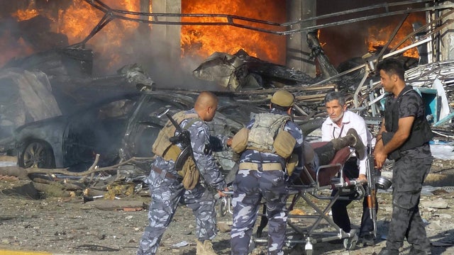 Iraqi emergency service personnel wheel a body at the site of a roadside bomb attack near under-construction buildings in the Kurdish-controlled northern Iraqi city of Kirkuk Aug. 23, 2014. 