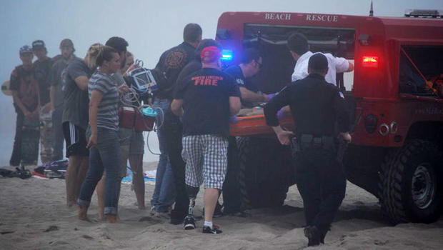 A 9-year-old girl who was trapped beneath the sand when a sand cave collapsed is put into an ambulance in Lincoln City, Ore., Aug. 29, 2014. 