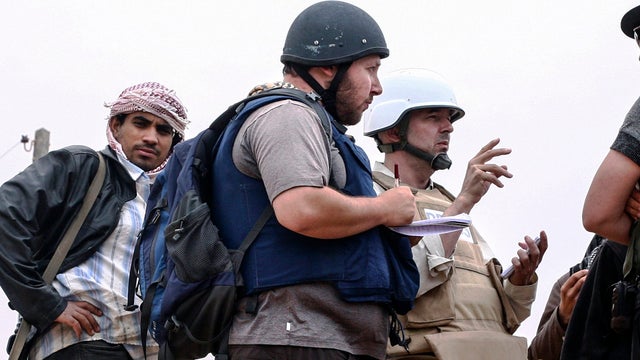 American journalist Steven Sotloff, center with black helmet, talks to Libyan rebels on the Al Dafniya front line 25 kilometers west of Misrata, June 2, 2011, in Misrata, Libya, in this handout image made available by the photographer 