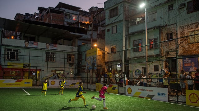 Children play soccer after the inauguration ceremony of the new technology pitch installed at Mineira favela in Rio de Janeiro, Brazil 