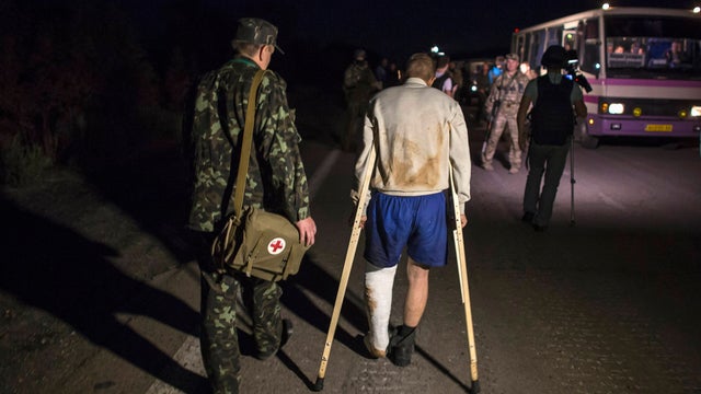 A member of the Ukrainian government forces, who is a prisoner-of-war (POW), walks along a road as he is being exchanged 