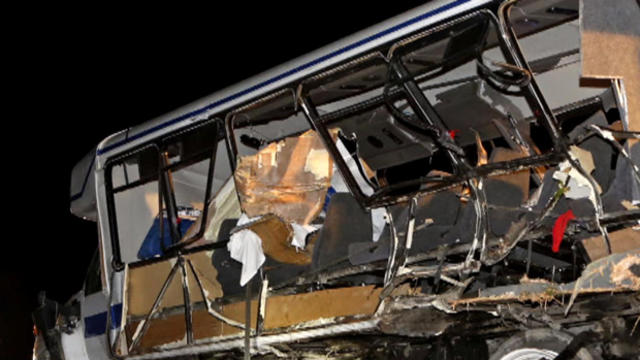 A wrecker removes a Texas college softball team's bus as Oklahoma Highway Patrol and emergency personnel work the scene of the fatal incident on Sept. 27, 2014, in Davis, Oklahoma 