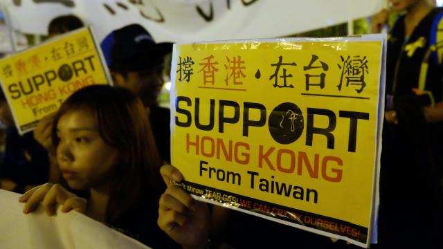 Students from Taiwan and Hong Kong display placards in front of the Freedom Square during a gathering in support of Hong Kong's pro-democracy protestors 