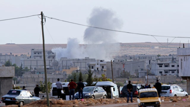 Smoke rises after a mortar landed in the Syrian town of Kobani, seen from the Turkish border town of Suruc 