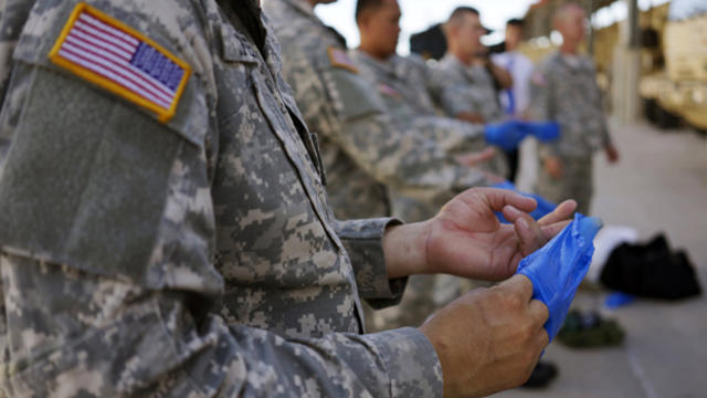 Soldiers from the U.S. Army 615th Engineer Company, 52nd Engineer Battalion, practice the proper way to remove protective gloves during the final session of personal protective equipment training at Fort Carson in Colorado Springs, Colorado, Oct. 23, 2014 