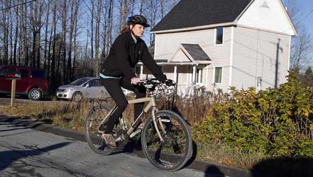 Nurse Kaci Hickox rides away from the home she is staying in on a rural road in Fort Kent, Maine, to take a bike ride Oct. 30, 2014. 