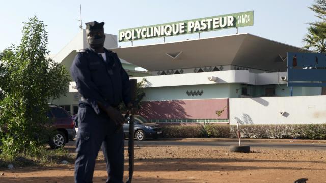 A police officer stands guard outside the quarantined Pasteur Clinic in Bamako 