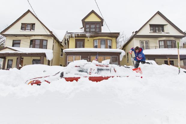 Lori Weishaar shovels snow from around her vehicle following an autumn snowstorm in Buffalo, N.Y., Nov. 20, 2014. 