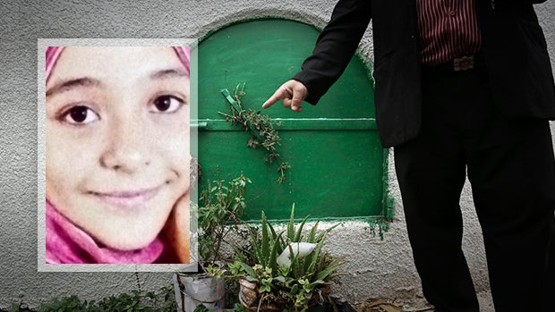 ​A man stands Nov. 5, 2014, in front of the grave of 13-year-old Suheir El-Batea, inset, who died undergoing the procedure of female genital mutilation performed by Dr. Raslan Fadl, in Dierb Biqtaris village, on the outskirts of the town of Aga in Dakahli 