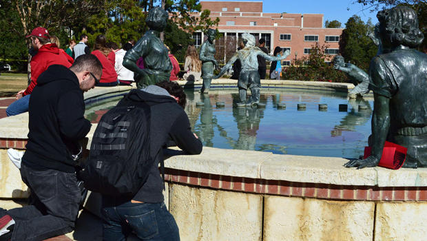 Josh Nieves, 20, a music student from Fort Myers, left, and Tim Kehl, 19, a junior finance student from Tallahassee, kneel at the fountain in front of the library and pray at Florida State University in Tallahassee, Fla., Nov. 20, 2014. 