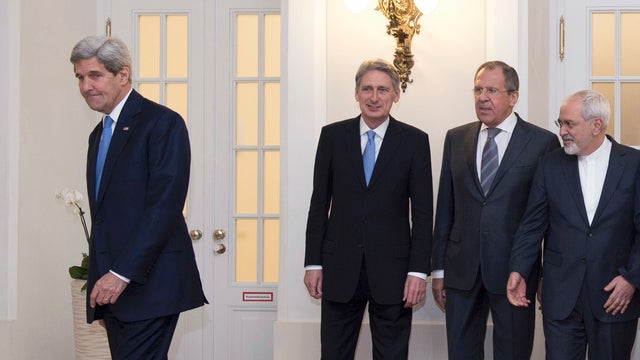 Secretary of State John Kerry steps out as Britain's Foreign Secretary Philip Hammond, Russian Foreign Minister Sergei Lavrov and Iranian Foreign Minister Javad Zarif, pose for photographers during their meeting in Vienna 