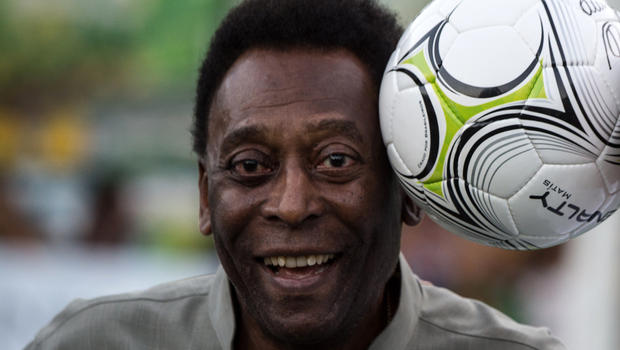 Legendary Brazilian football player Pele poses with a ball during the inauguration ceremony of the new technology football pitch installed at Mineira favela in Rio de Janeiro, Brazil, Sept. 10, 2014. 
